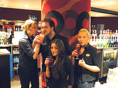 Ilveksen henkilökunta irrottelee työaikana lasit kädessä.