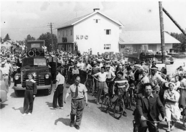 Kuva: Suomen Urheilumuseo CC BY SA Soihtuviesti Himangalla 12.7.1952. Viestiä seuraamaan tullut yleisö täyttää maantien, kuvassa vasemmalla auton edessä soihdunkantaja Anna-Liisa Himanka.