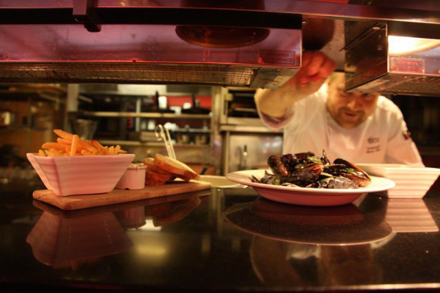 Keittiöpäällikkö Markus Peltonen viimeistelee kympin sinisimpukka-annoksen.