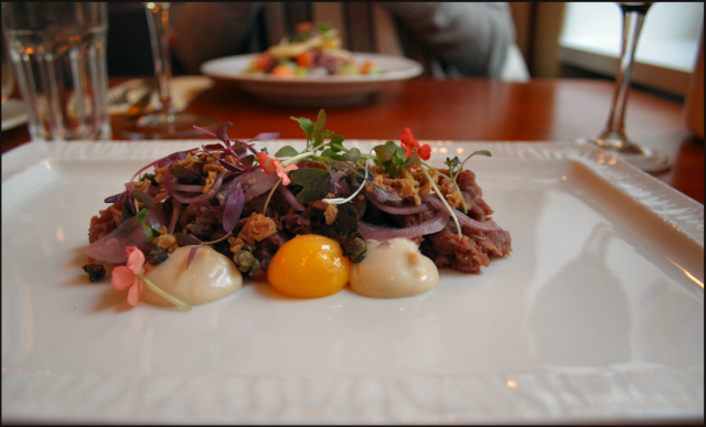 Härkätartar - Dijonmajoneesia, keltuaista ja rapeaa sipulia. / Toisena alkupalana taustalla Västerbotten-juustosalaattia.