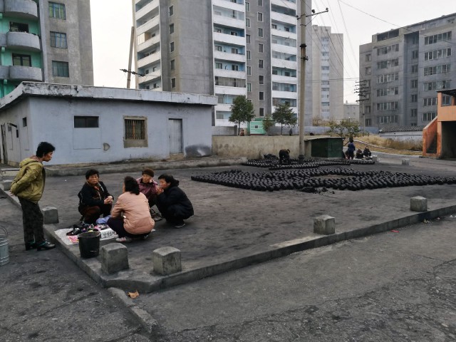 Kivihiili sekoitetaan (käsin tietenkin) mutaan, jotta saadaan sopivia poltettavia brikettejä ja talot pysyvät lämpiminä.