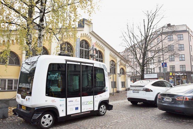 Robottibussit ja Tesla nätisti parkissa Smart City -seminaarin pihassa Korjaamolla.