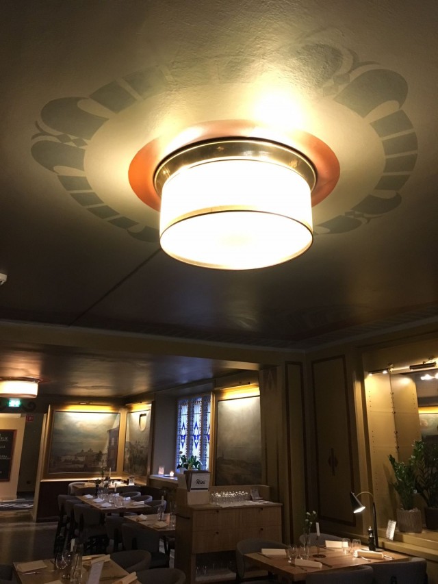 Upeat vanhat valaisimet ravintolasalin katossa.