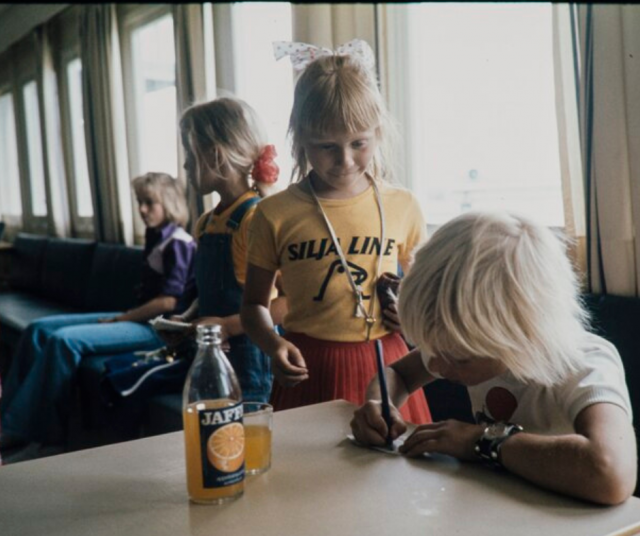 Vaahteranmäen Eemelin näyttelijä jakeli nimikirjoituksia Suomessa 1973. Huomatkaa Jaffa-pullo pöydällä.